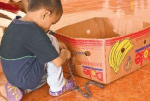 Una caja impulsada por una tira de tela se convirtió en juguete para los niños en el albergue de la iglesia Ágape en Sarapiquí.